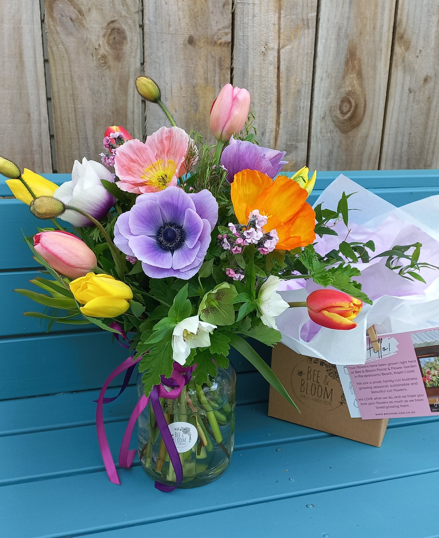 Colorful bouquet of flowers on a blue surface with a wooden background