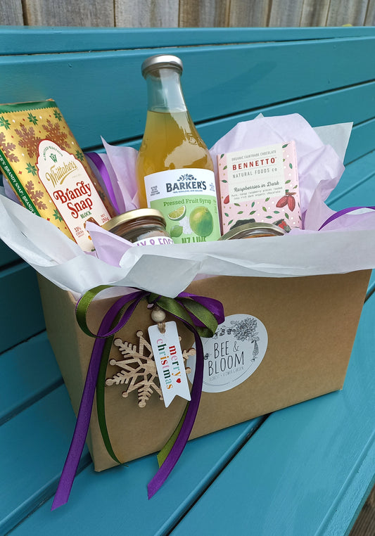 Gift set with bottles and a bouquet on a teal surface