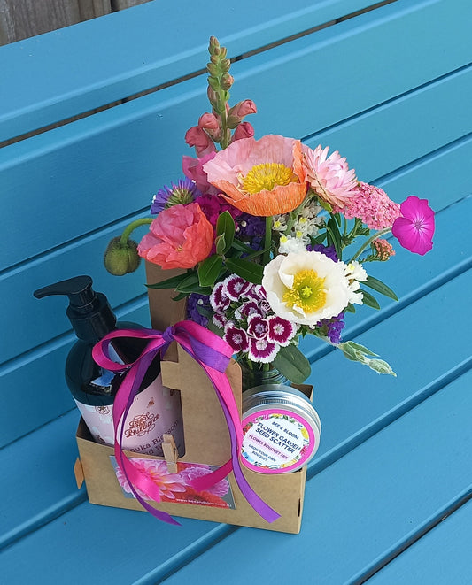 Floral arrangement and gift box on a blue wooden surface