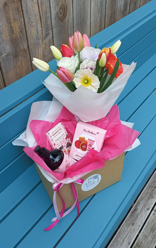 Gift box with fresh flowers on a blue bench
