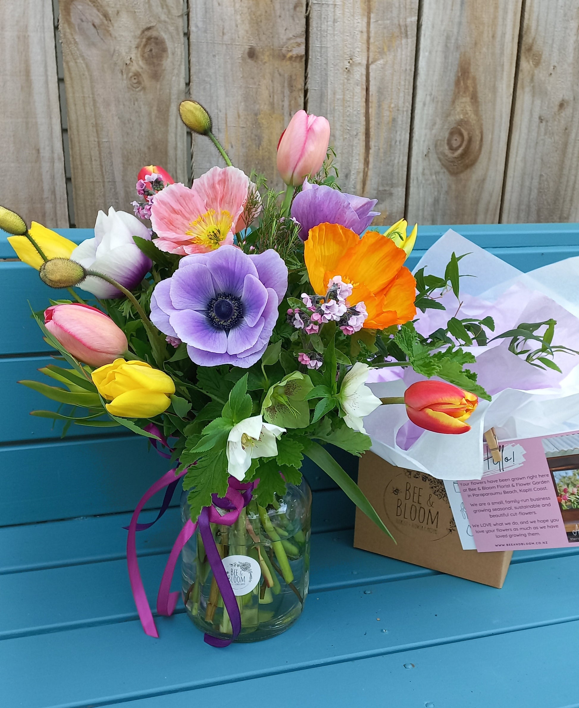 Colorful bouquet of flowers on a blue surface with a wooden background