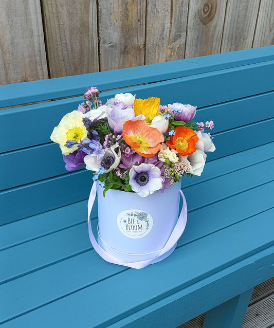 Colorful flower arrangement on a blue chair with a wooden floor background