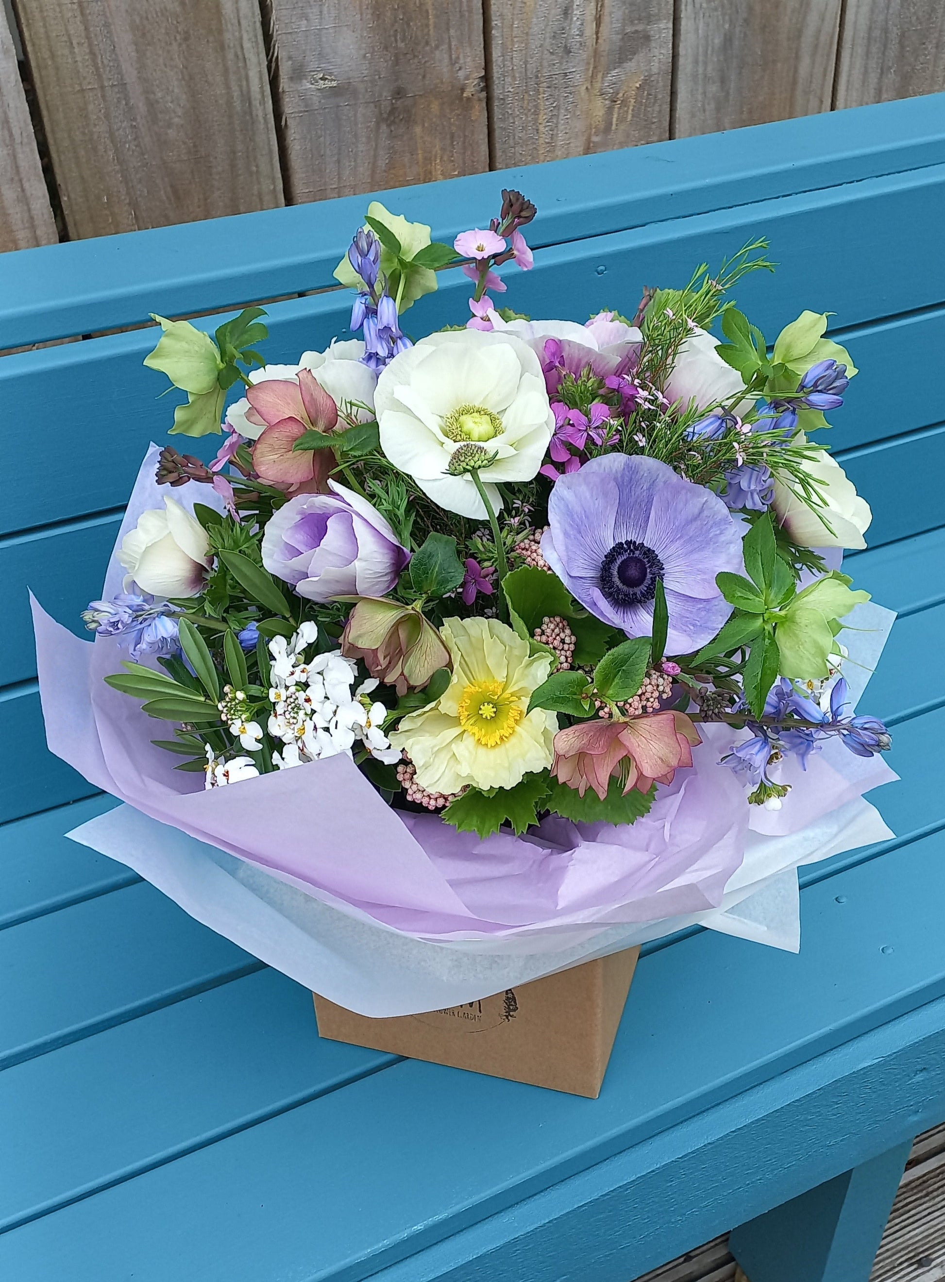 Bouquet of flowers on a blue wooden bench outdoors