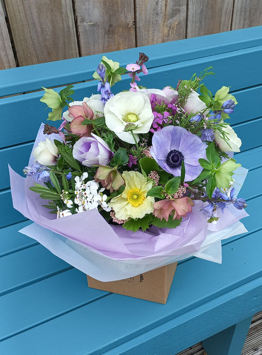 Bouquet of flowers on a blue wooden bench outdoors
