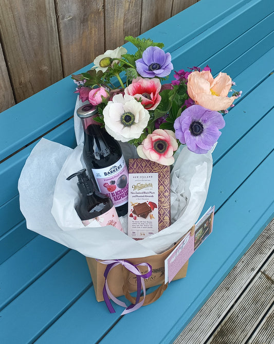 Bouquet of flowers and bottles on a blue surface with wooden background