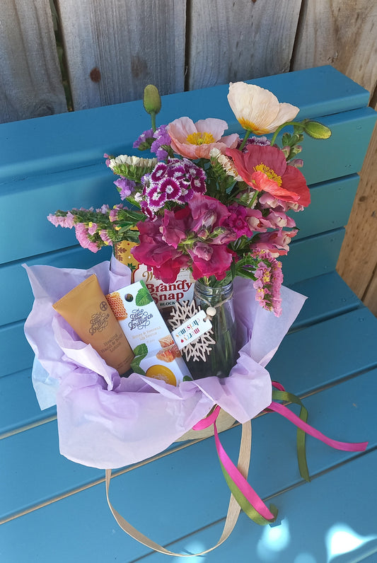 Bouquet of flowers and a gift on a blue wooden surface