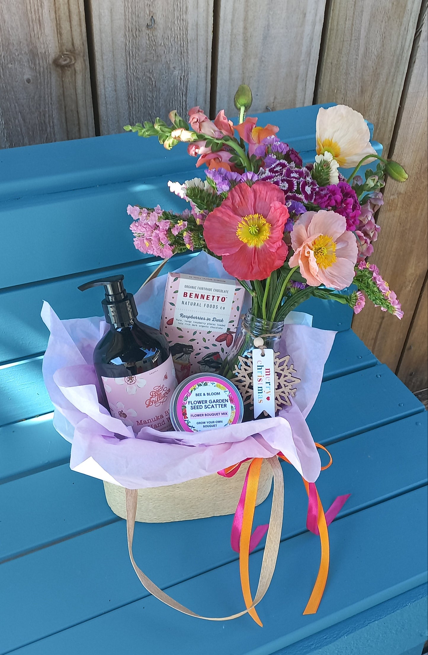Bouquet of flowers and a bottle on a blue wooden surface