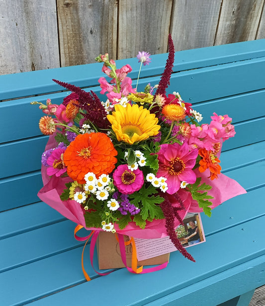 Colorful bouquet of flowers on a blue wooden surface