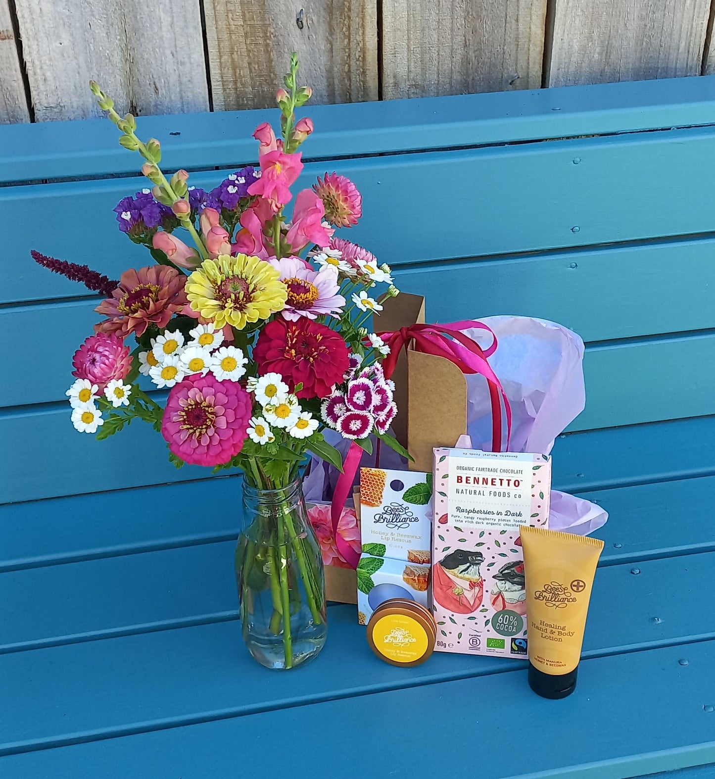 Colorful bouquet of flowers on a blue chair with a wooden background