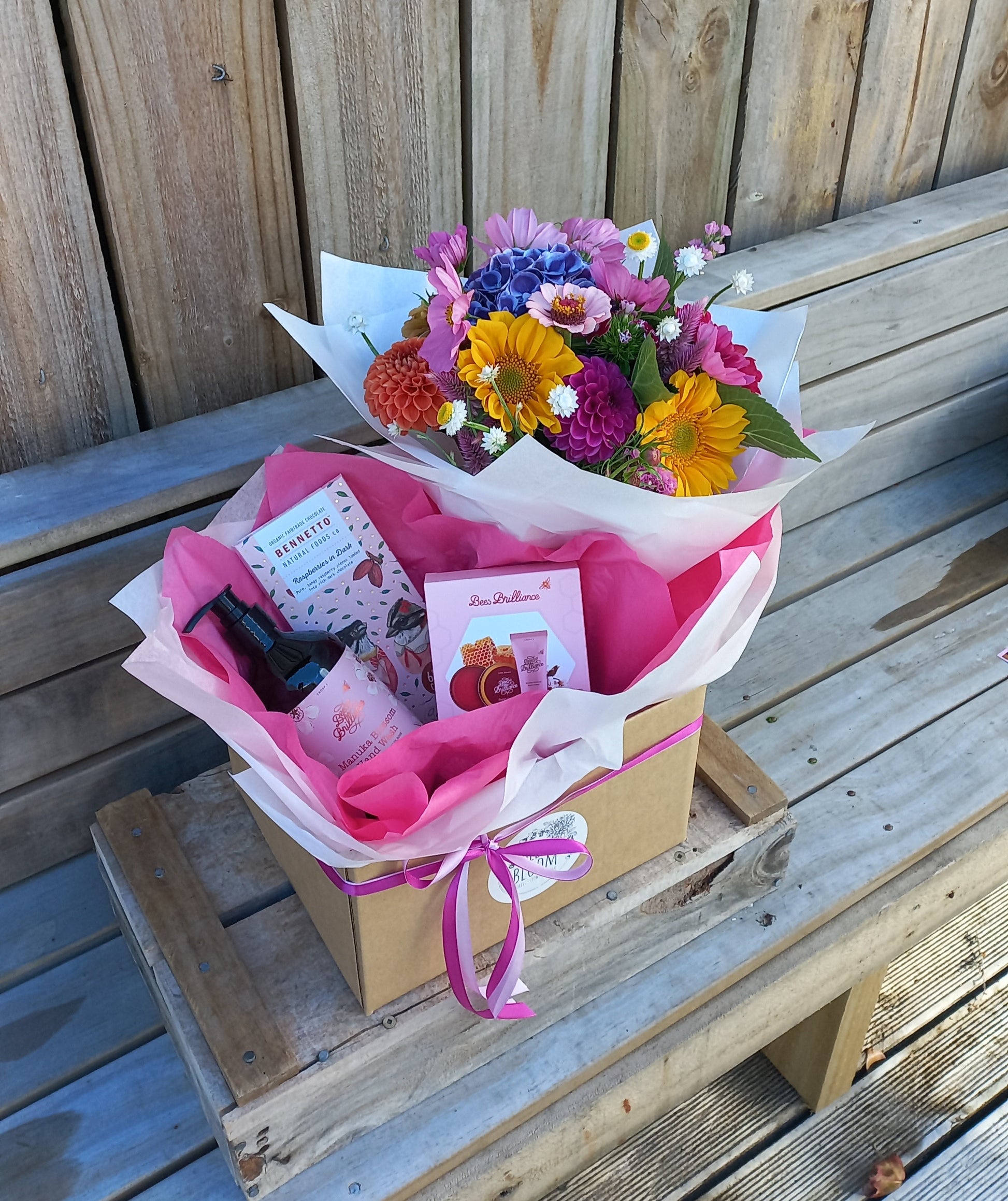 Bouquet of flowers and a gift box on a wooden surface