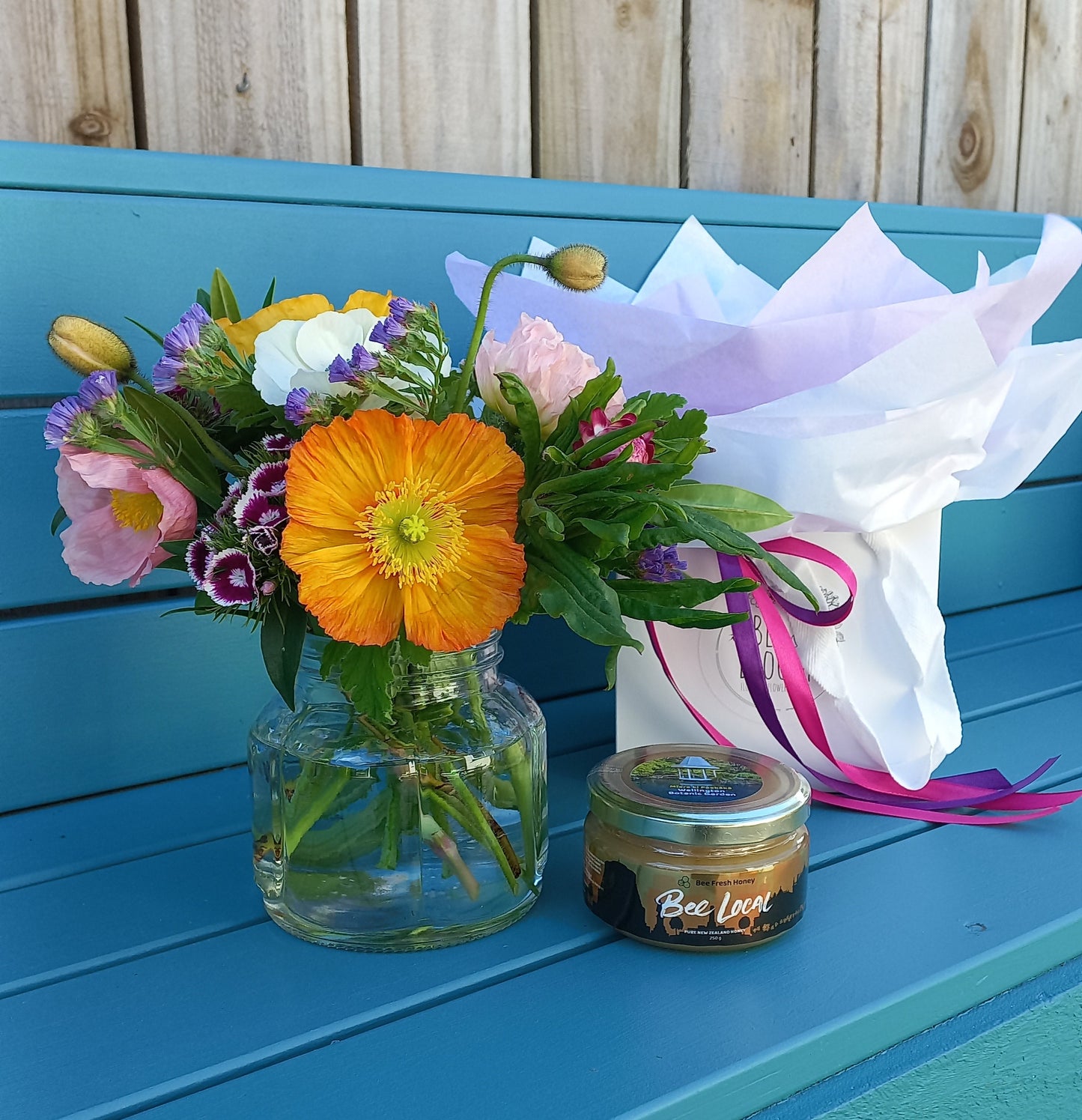 Bouquet of flowers with a bottle on a blue surface