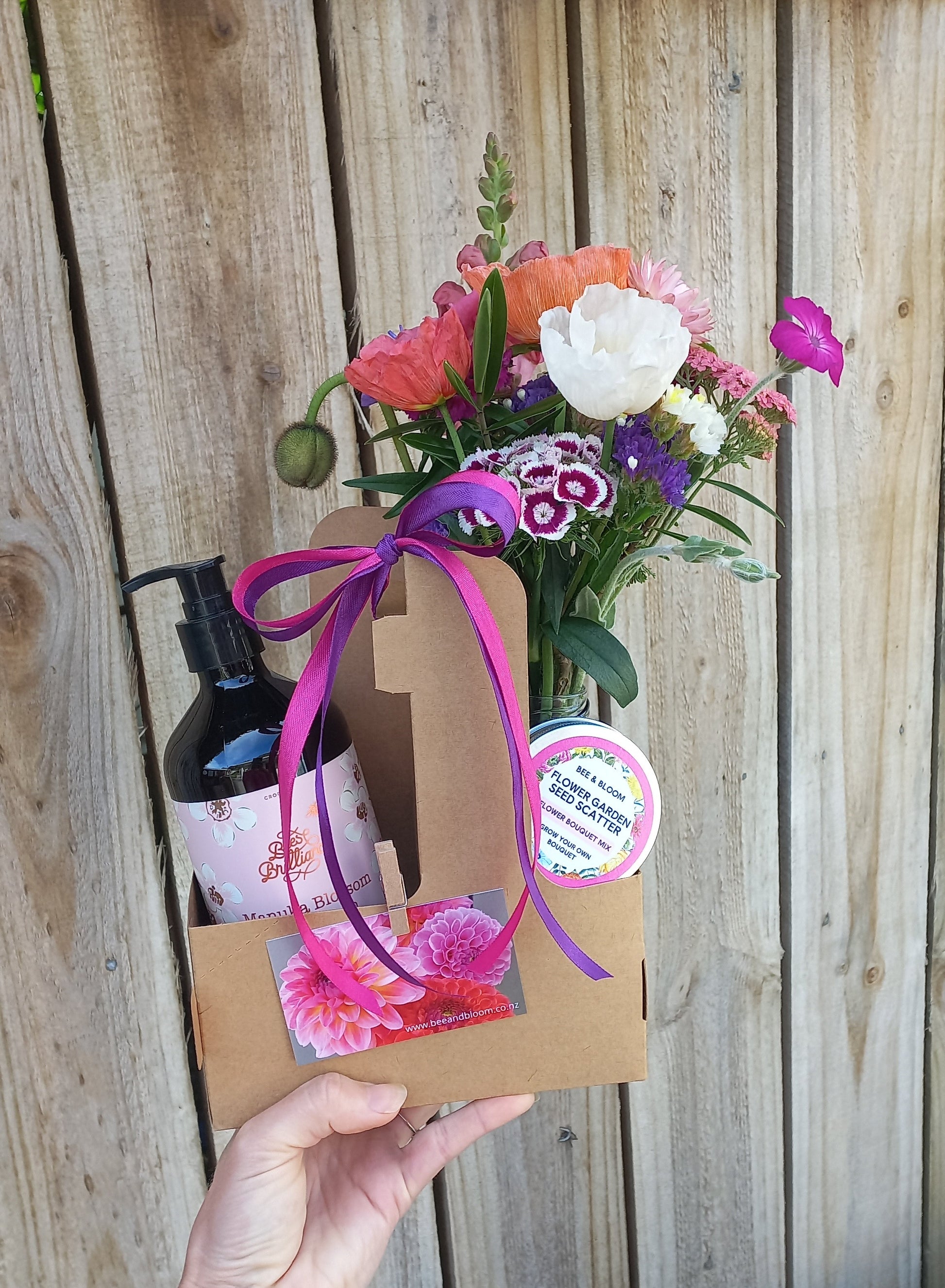 Box with flowers and a card on a wooden surface