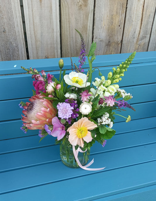 Bouquet of flowers on a blue chair with wooden background